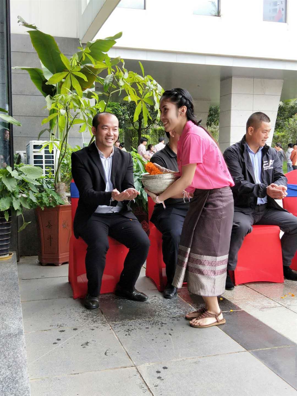 老撾駐廣西留學(xué)生代表將浸有花瓣的香水灑客人的手上，表示對嘉賓的美好祝福（圖一）