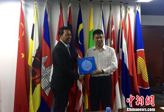 中國(guó)—東盟博覽會(huì)秘書(shū)處副秘書(shū)長(zhǎng)黃平西（右）與柬埔寨新聞部新聞與傳播總司副總司長(zhǎng)春占皮侖（左）互贈(zèng)禮物。