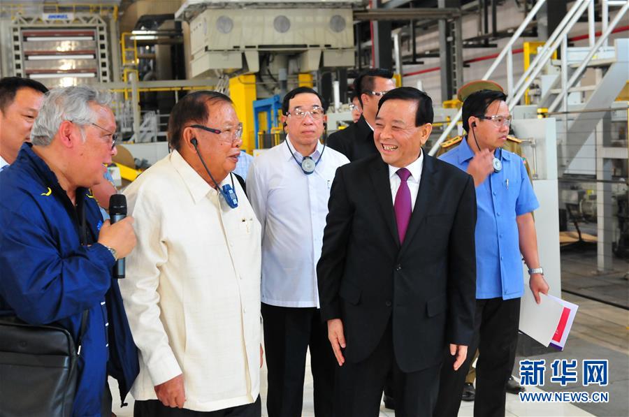 3月10日，在老撾沙灣拿吉省車邦縣，老撾人民革命黨中央總書記、國家主席本揚（左二）在山東太陽紙業(yè)股份有限公司董事長李洪信（右二）的陪同下視察公司。 新華社記者章建華攝